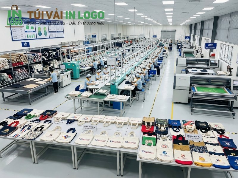 Toàn cảnh xưởng sản xuất túi vải quà tặng in logo, hình ảnh theo yêu cầu với đầy đủ quy trình từ nguyên liệu, cắt vải, dây chuyền may túi đến khu vực in ấn và trưng bày thành phẩm túi tote, túi vải thương hiệu.