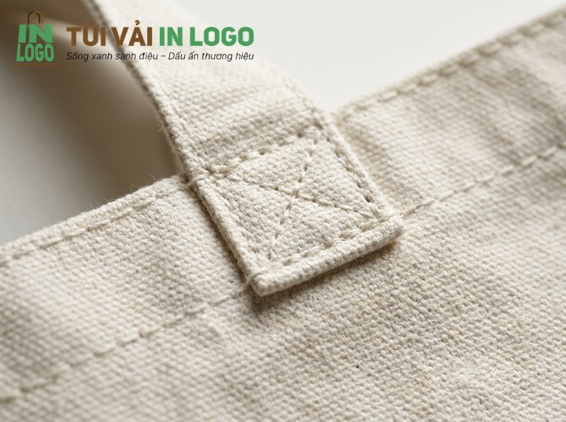 Túi vải canvas in logo, chi tiết đường may chắc chắn và tỉ mỉ trên quai túi màu be, thể hiện độ bền và chất lượng cao cho quà tặng doanh nghiệp.