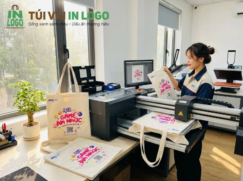 Hình ảnh một nhân viên đang kiểm tra túi vải canvas in logo nhiều màu sắc, sắc nét tại xưởng in, minh họa quy trình in logo lên túi vải bằng công nghệ hiện đại, phù hợp cho giải pháp in PET logo.