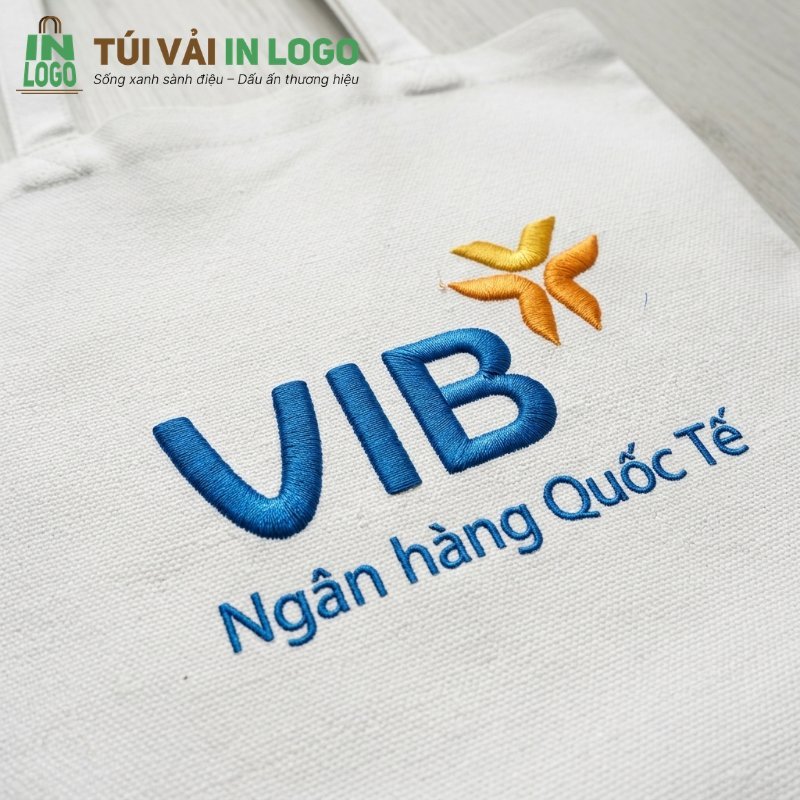 Túi vải canvas trắng in logo VIB Bank thêu nổi màu xanh và vàng, thể hiện quà tặng doanh nghiệp bền bỉ, thời trang và thân thiện môi trường.